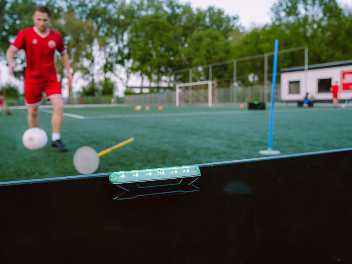 Voetbal ligt op een Beam met de leds aan, speler klaar om te schieten