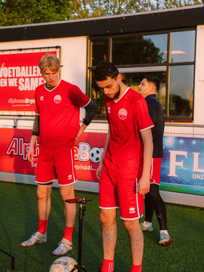 Twee jeugdspelers van Alphense Boys bekijken hun score bij het clubhuis