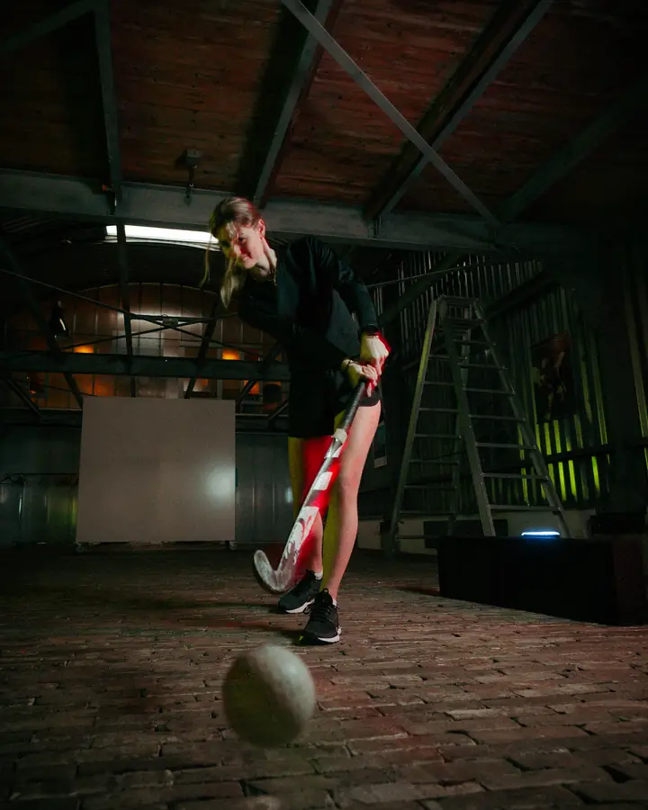 Hockey player with a stick and a Beam indoors