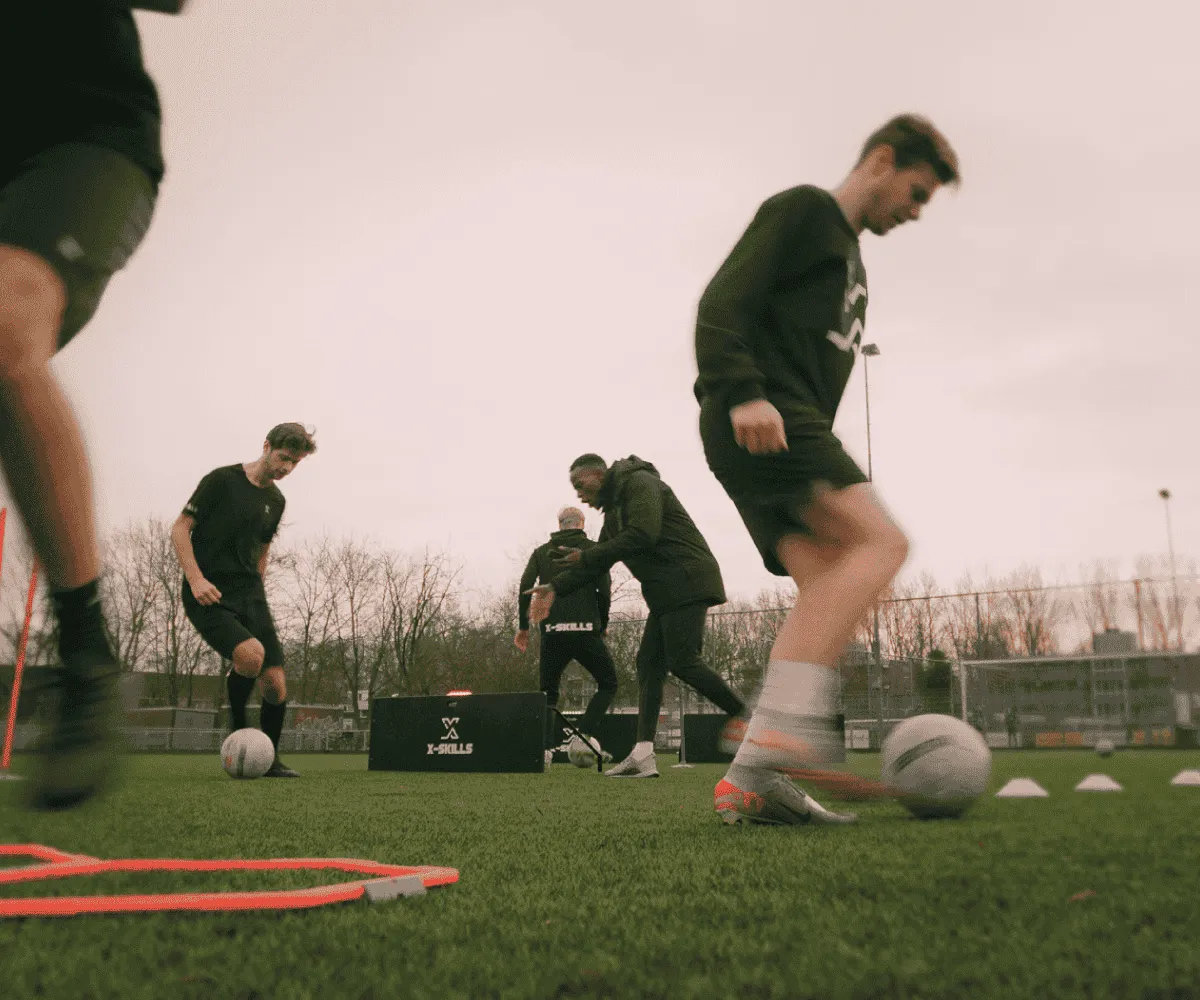 Coach guiding a football team during an X-Skills session
