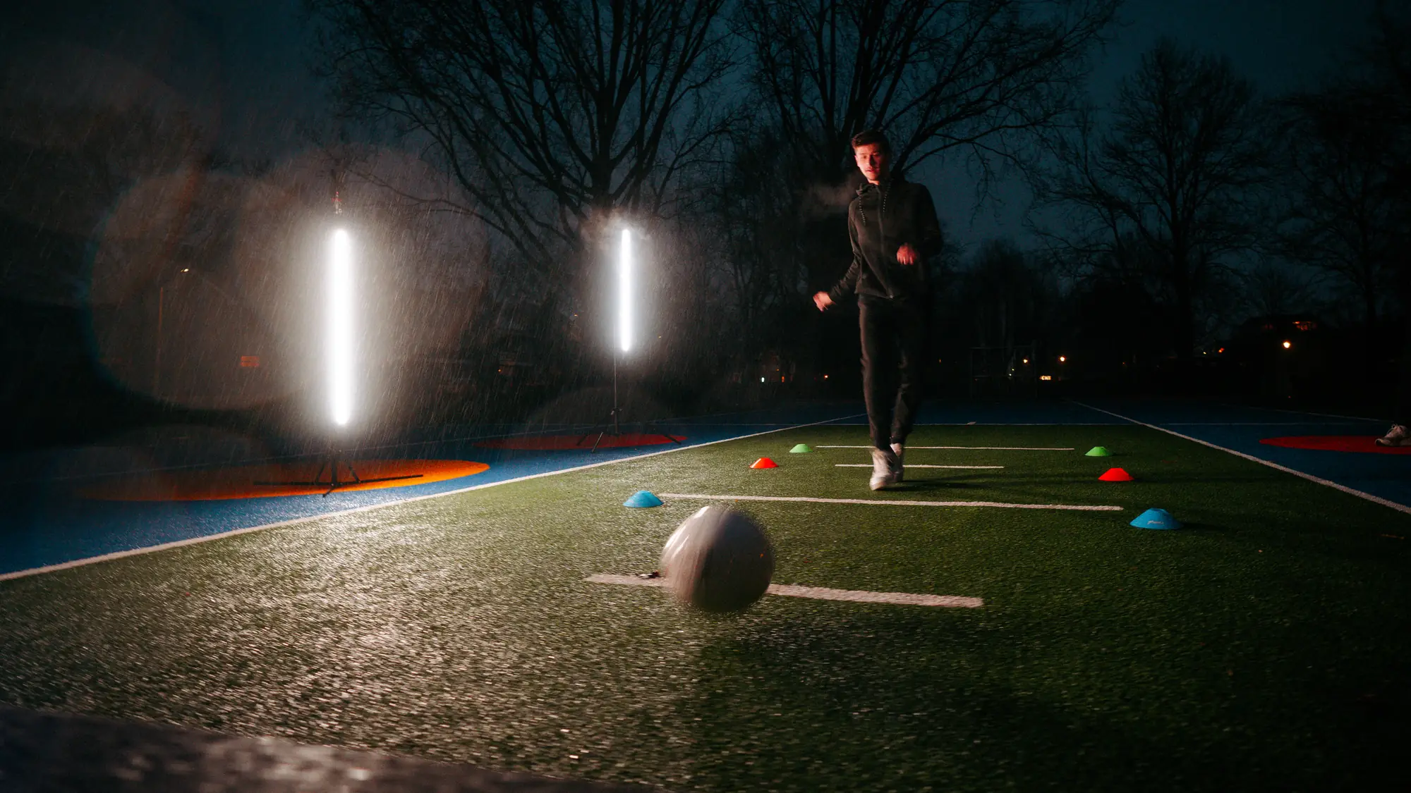 Two Beams light up at dusk as a footballer sets off